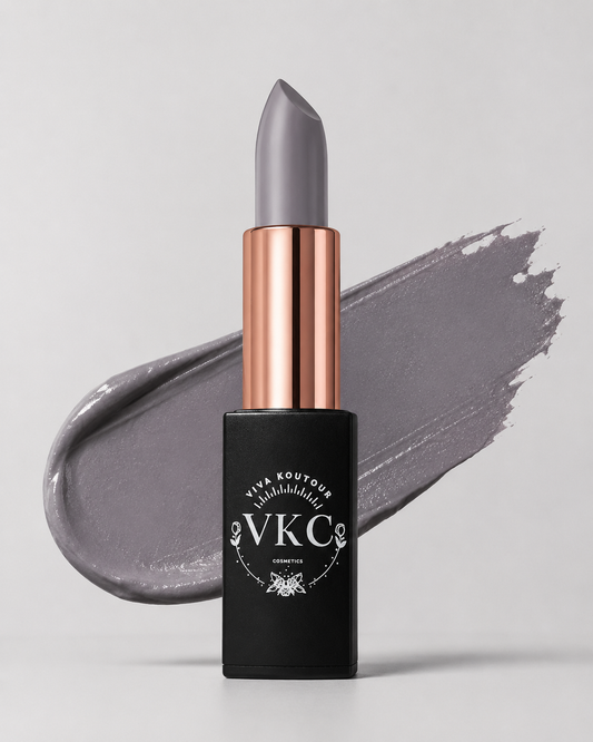Gray lipstick with rose gold cap and black container on gray background