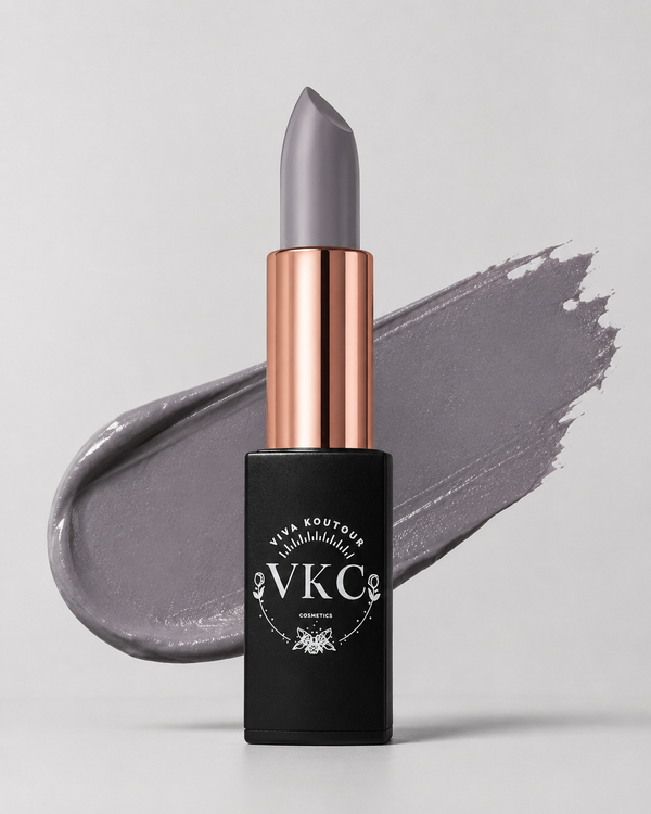 Gray lipstick with rose gold cap and black container on gray background